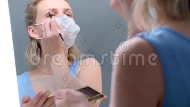 4k. <strong>金</strong>发女孩在医用防护面罩做眼妆，涂抹眼影.. 在米尔罗看去。 女人不怕冷